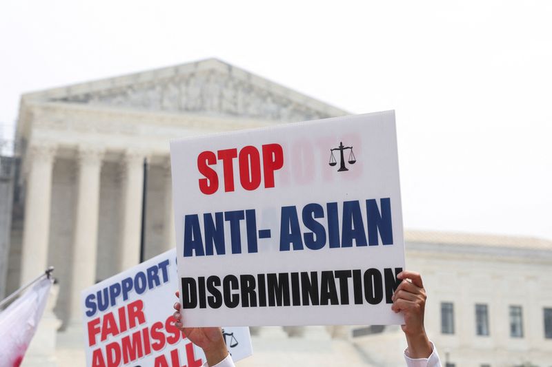 &copy; Reuters. Protesters hold signs as demonstrators for and against the U.S. Supreme Court decision to strike down race-conscious student admissions programs at Harvard University and the University of North Carolina confront each other, in Washington, U.S., June 29, 