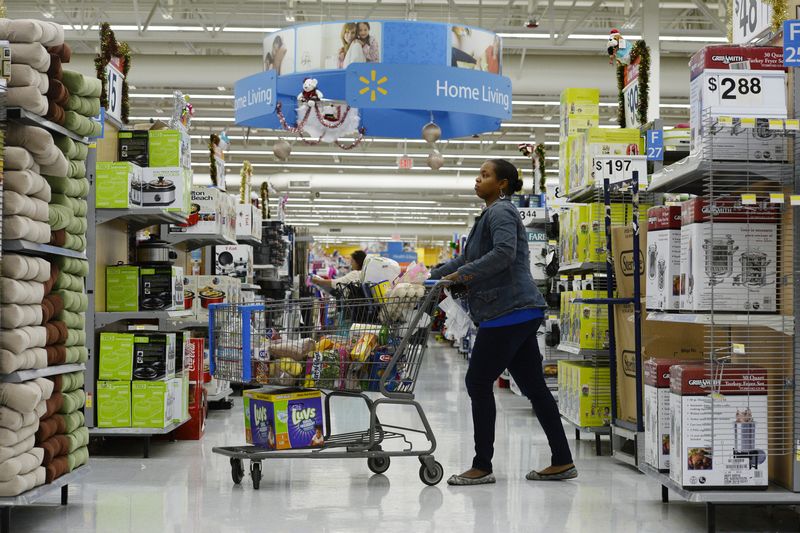 © Reuters. FILE PHOTO: A customer pushes her shopping cart through the aisles at a Walmart store in the Porter Ranch section of Los Angeles November 26, 2013.  REUTERS/Kevork Djansezian/File Photo