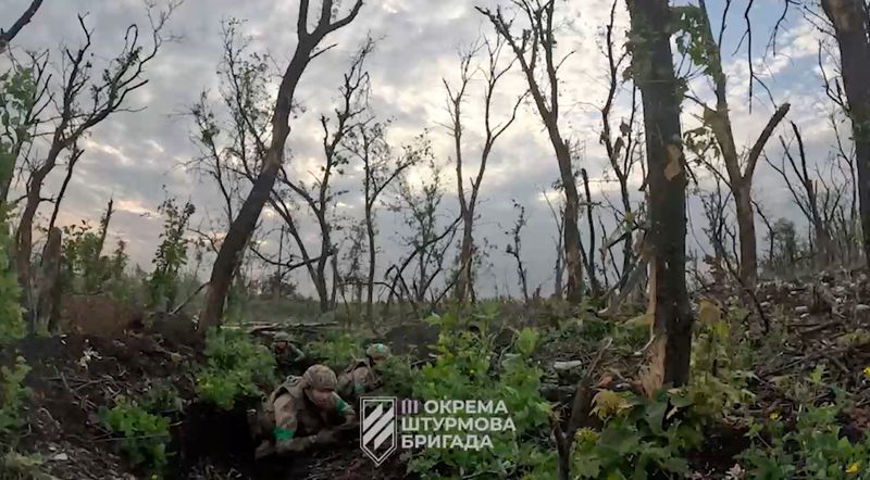 &copy; Reuters. اثنان من أفراد القوات المسلحة الأوكرانية يتجمعان في موقع بالقرب من باخموت في إقليم دونيتسك بأوكرانيا في صورة مأخوذة من مقطع مصور صدر يوم 25 ي