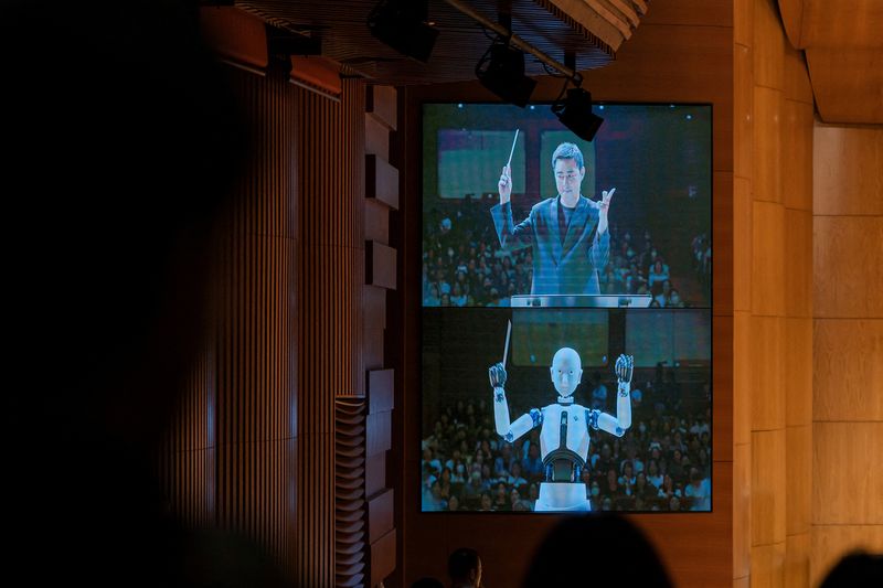 &copy; Reuters. روبوت أندرويد (إيفر6) يظهر على شاشة بينما يقود حفلا للأوركسترا الوطني في كوريا الجنوبية برفقة تشوي سو-يول الذي قاد العرض إلى جانبه في سول يوم 