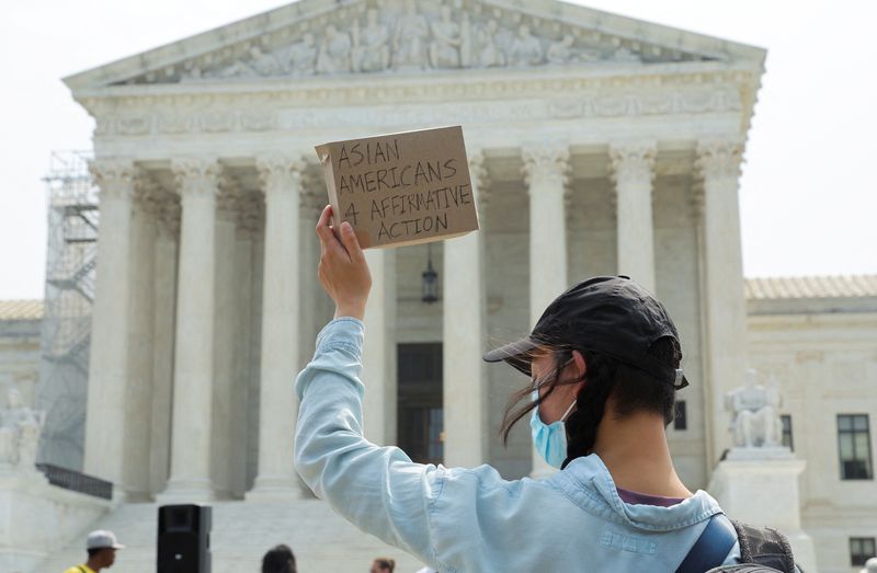 © Reuters. An Asian-American supporter of affirmative action policies protests outside the U.S. Supreme Court a day after the court struck down race-conscious admissions programs at Harvard University and the University of North Carolina, effectively prohibiting affirmative action policies long used to raise the number of Black, Hispanic and other underrepresented minority students on American campuses, in Washington, U.S. June 30, 2023.  REUTERS/Jim Bourg