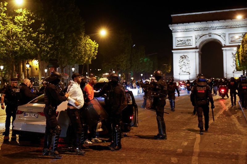 &copy; Reuters. Des policiers arrêtent des jeunes lors de la cinquième nuit de manifestations après la mort de Nahel, un adolescent de 17 ans tué par un policier français à Nanterre lors d'un contrôle routier, dans le quartier des Champs-Élysées, à Paris. /Phot