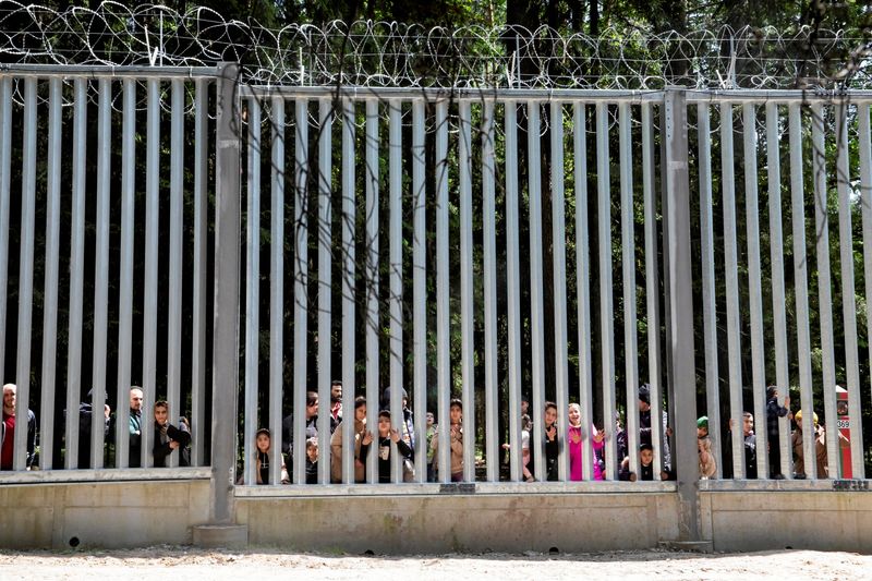 &copy; Reuters. Des migrants se tiennent près du mur à la frontière entre la Pologne et la Biélorussie, près de Białowieża, en Pologne. /Photo prise le 28 mai 2023/REUTERS/Agnieszka Sadowska/Agencja Wyborcza.pl