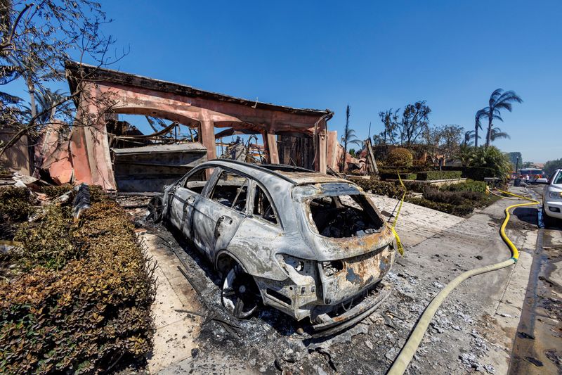 &copy; Reuters. FILE PHOTO: A burned car and the remains of a burned-out home are shown after a fast-moving wildfire ripped through an affluent neighborhood in Laguna Niguel, California, U.S., May 12, 2022. REUTERS/Mike Blake/File Photo