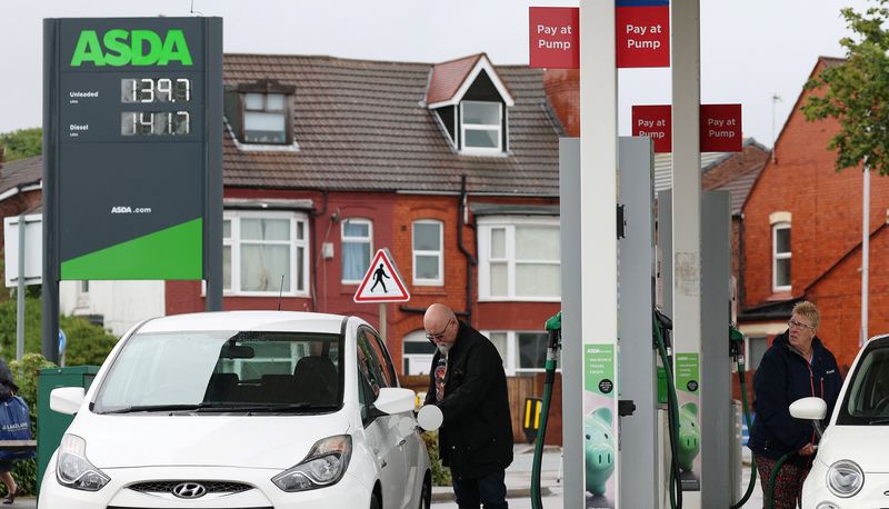 © Reuters. People put fuel in their cars at a filling station at an ASDA supermarket in Birkenhead, Britain, July 3, 2023. REUTERS/Phil Noble