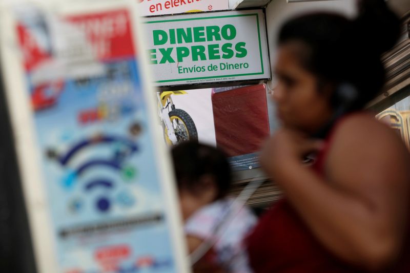 &copy; Reuters. FOTO DE ARCHIVO. Una mujer habla por teléfono frente a una oficina de cambio de moneda en Ciudad Juárez, México. 1 de julio de 2017 REUTERS/José Luis González