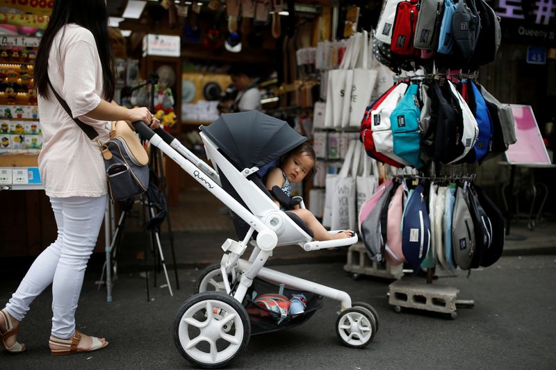 &copy; Reuters. A woman pushing her baby in a stroller shops in the Hongdae area of Seoul, South Korea, June 29, 2016. Picture taken June 29, 2016. REUTERS/Kim Hong-Ji/File Photo