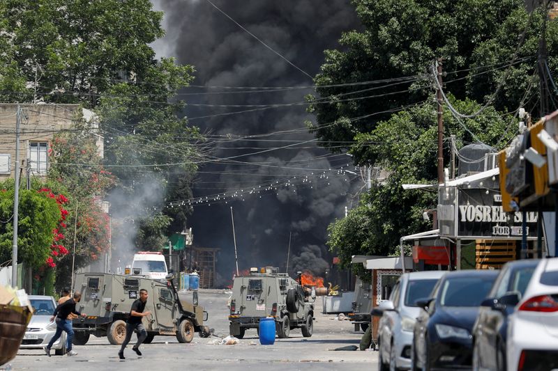 © Reuters.  ７月３日、ヨルダン川西岸のジェニンでイスラエル軍が夜間に急襲作戦を実施し、パレスチナ自治政府保健省は少なくとも８人が死亡したと発表した。写真は同日、ジェニンでイスラエル軍との衝突から逃げるパレスチナの住民（２０２３年　ロイター/Raneen Sawafta）