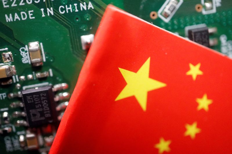 &copy; Reuters. A Chinese flag is displayed next to a "Made in China" sign seen on a printed circuit board with semiconductor chips, in this illustration picture taken February 17, 2023. REUTERS/Florence Lo/Illustration/File photo