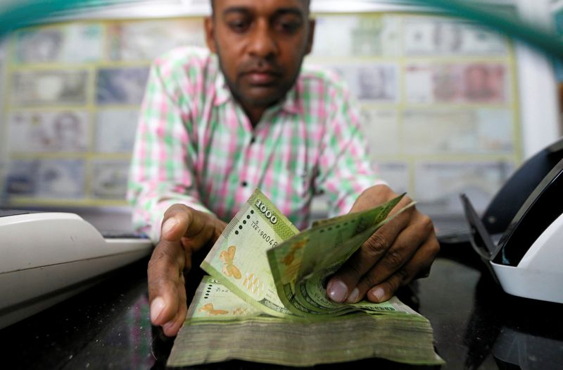 © Reuters. A man counts Sri Lankan rupees notes at a counter of a currency exchange shop in Colombo, Sri Lanka November 14, 2017. REUTERS/Dinuka Liyanawatte