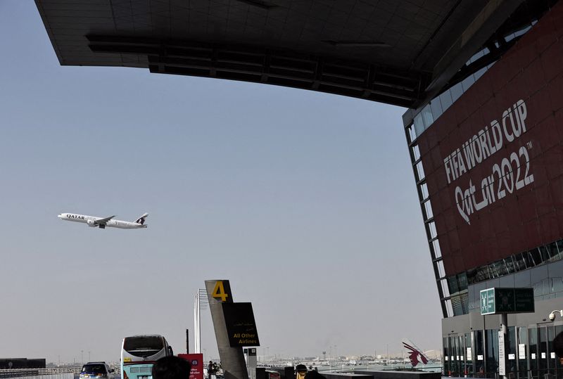 &copy; Reuters. FILE PHOTO: Soccer Football - FIFA World Cup Qatar 2022 Preview - Hamad International Airport, Doha, Qatar - November 10, 2022 A Qatar World Cup promotion is seen with a Qatar Airways aeroplane in flight at Hamad International Airport ahead of the World C