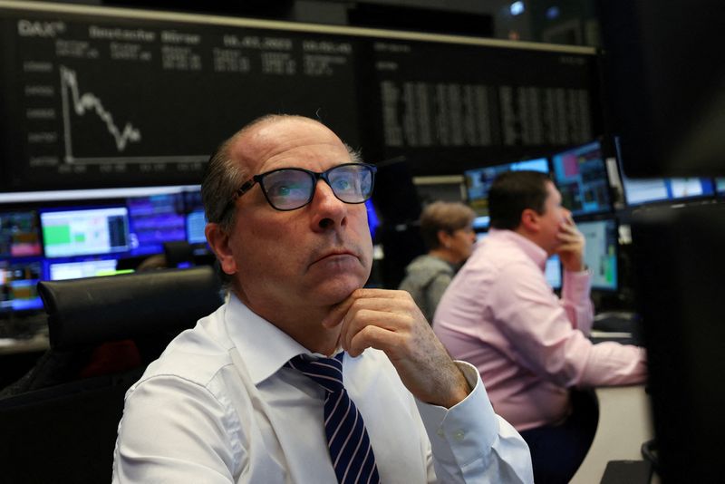 &copy; Reuters. FOTO DE ARCHIVO: Un agente de bolsa mira sus pantallas frente al gráfico del índice de precios de acciones DAX en la bolsa de Fráncfort, Alemania. 16 de marzo de 2023. REUTERS/Kai Pfaffenbach
