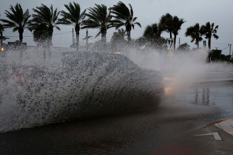 © Reuters. FILE PHOTO: A car drives by a flooded street ahead of the expected arrival of Hurricane Nicole, in Daytona Beach, Florida, U.S., November 9, 2022. REUTERS/Marco Bello/File Photo