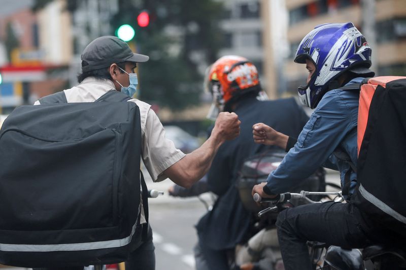 &copy; Reuters. FILE PHOTO: Pablo Toro, Venezuelan delivery worker talk to another delivery worker at a stoplight stop in Bogota, Colombia June 15, 2021. Picture taken June 15, 2021. REUTERS/Luisa Gonzalez/File Photo