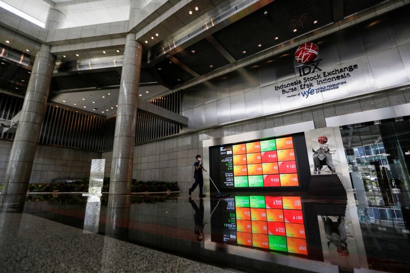 &copy; Reuters. FILE PHOTO: A worker wearing a protective mask cleans the floor near an electronic board displaying the stock market index at the Indonesia Stock Exchange (IDX), as the outbreak of the coronavirus disease (COVID-19) continues, in Jakarta, Indonesia, Septe