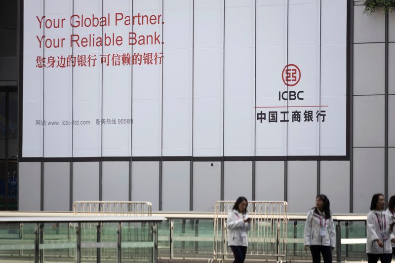 &copy; Reuters. FILE PHOTO: People walk past a sign of the Industrial and Commercial Bank of China (ICBC) at the venue for the second China International Import Expo (CIIE) in Shanghai, China October 31, 2019.  REUTERS/Stringer  