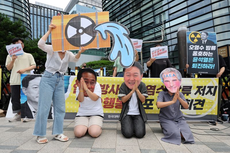 &copy; Reuters. Students wearing masks featuring Japanese Prime Minister Fumio Kishida, South Korean President Yoon Suk Yeol and International Atomic Energy Agency (IAEA) chief Rafael Grossi attend a protest against Japan's plan to discharge treated radioactive water fro