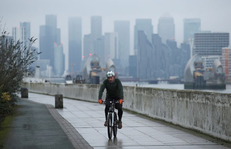 &copy; Reuters. FILE PHOTO: Buildings are seen in the Canary Wharf business district, as a man cycles along a path, in London, Britain January 27, 2021. REUTERS/Peter Cziborra/File Photo