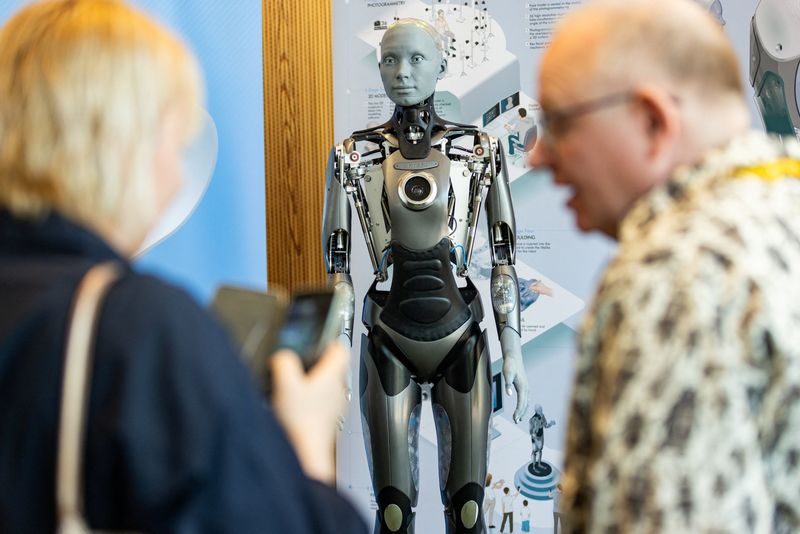&copy; Reuters.  ７月７日、スイスのジュネーブで人工知能（ＡＩ）を搭載した人型ロボット９体とそれらの設計者が集まり、ＡＩの可能性や問題点などを話し合う会合が開かれた。写真はジュネーブで展