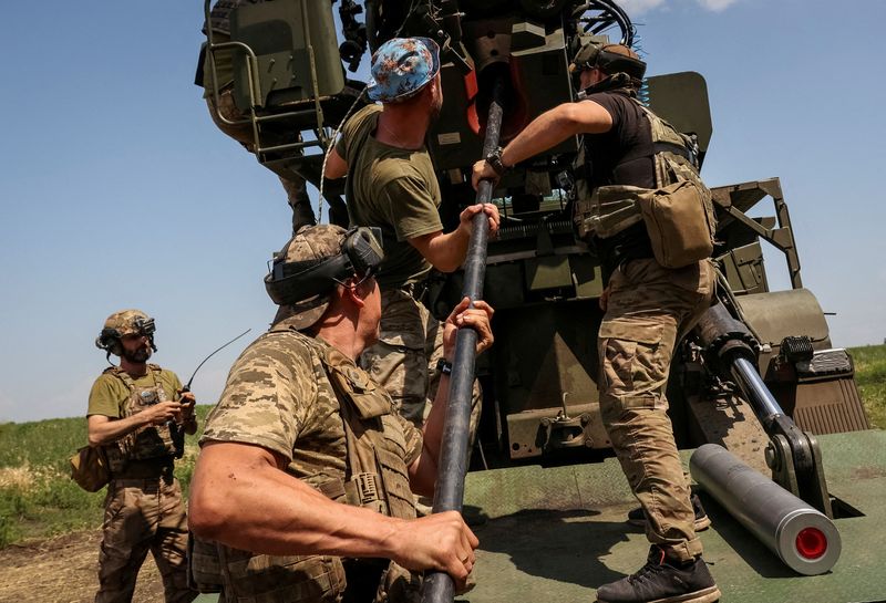 © Reuters. FILE PHOTO: Ukrainian servicemen of the 57th Kost Hordiienko Separate Motorised Infantry Brigade prepare to fire a 2S22 Bohdana self-propelled howitzer towards Russian troops, amid Russia's attack on Ukraine, at a position near the city of Bakhmut in Donetsk region, Ukraine July 5, 2023. REUTERS/Sofiia Gatilova/File Photo