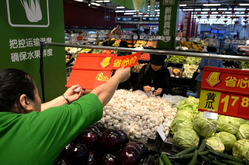 &copy; Reuters. A staff member inserts a price tag for vegetable at a Walmart in Beijing, China, September 23, 2019.  REUTERS/Tingshu Wang