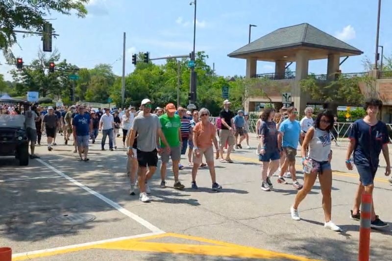 &copy; Reuters. FILE PHOTO: People walk and gather to commemorate victims of highland park shooting a year later, in Highland Park, Illinois, U.S., July 4, 2023, in this screen grab obtained from a social media video. Ewa Malcher/Dziennik Zwiazkowy/Polish Daily News /via