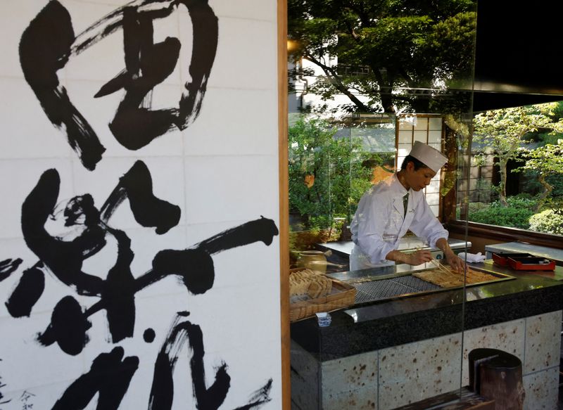 © Reuters. A chef cooks tofu as he prepares a dish before the opening for dinner hour at Ukai, a traditional Japanese restaurant, in Tokyo,  Japan, July 6, 2023. REUTERS/Kim Kyung-Hoon