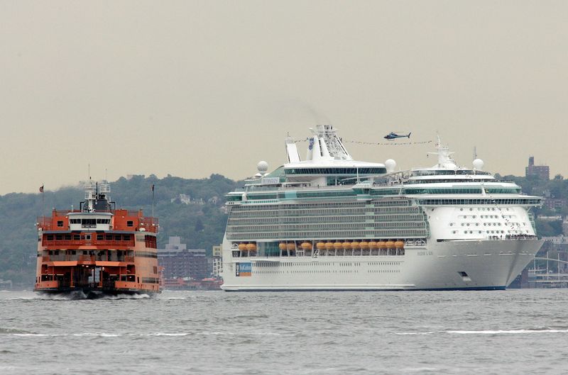 © Reuters. FILE PHOTO: The Staten Island Ferry cruises past the Royal Caribbean cruise ship Freedom of the Seas (R) as it makes its way up the Hudson River in New York May 10, 2006. REUTERS/Keith Bedford/File Photo