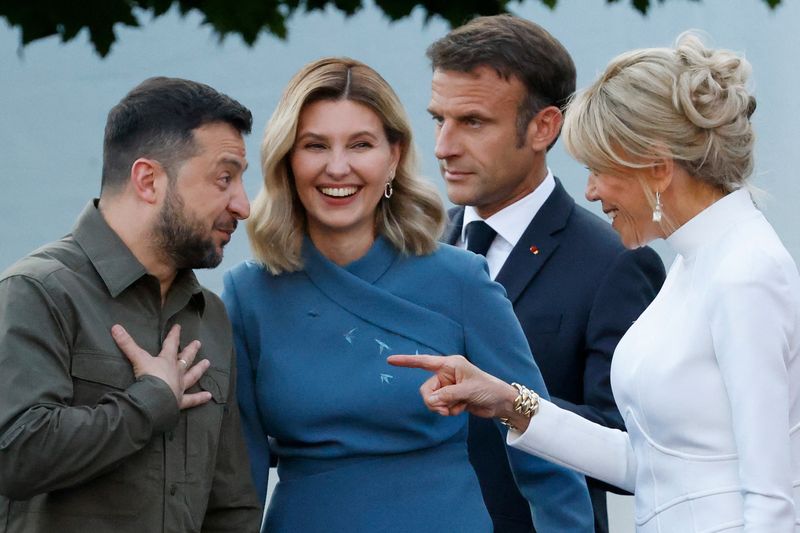 &copy; Reuters. Ukraine's President Volodymyr Zelenskiy and his wife Olena Zelenska react next to France's President Emmanuel Macron and French President's wife Brigitte Macron ahead of the social dinner during the NATO summit, at the Presidential Palace in Vilnius, Lith