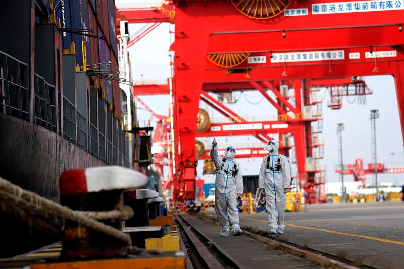 &copy; Reuters. FILE PHOTO: Border police officers in protective suits patrol next to a container ship at the Nanjing port in Jiangsu province, China July 10, 2022. China Daily via REUTERS  