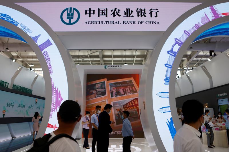 &copy; Reuters. FILE PHOTO: People walk past the Agricultural Bank of China booth at the 2021 China International Fair for Trade in Services (CIFTIS) in Beijing, China September 3, 2021. REUTERS/Florence Lo
