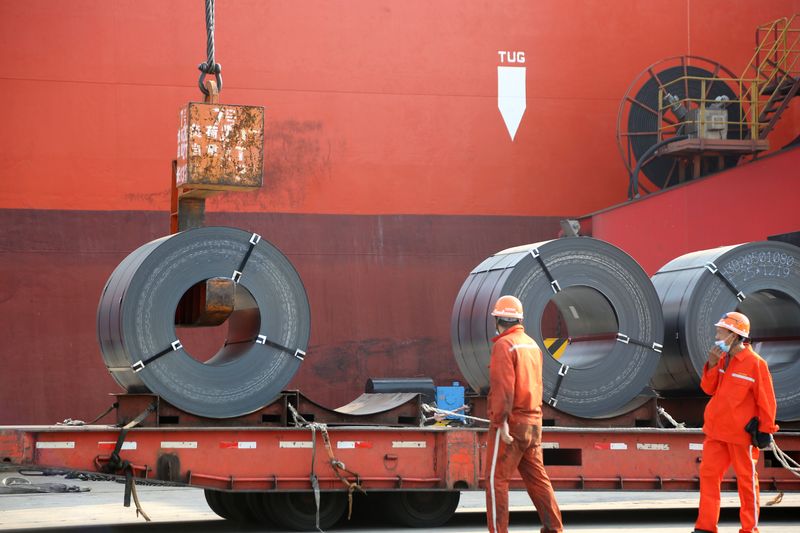 © Reuters. FILE PHOTO: Workers wearing face masks following the coronavirus disease (COVID-19) outbreak load steel products for export to a cargo ship at a port in Lianyungang, Jiangsu province, China May 27, 2020. China Daily via REUTERS 