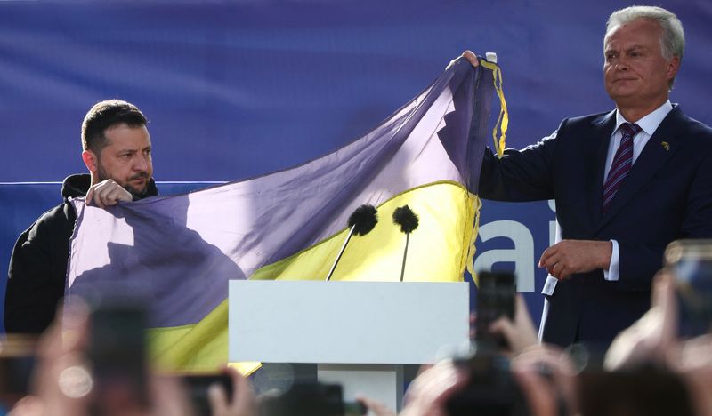 &copy; Reuters. Ukrainian President Volodymyr Zelenskiy and Lithuanian President Gitanas Nauseda hold a flag as they attend a ceremony during which a Ukrainian flag from the frontline of the war with Russia is delivered by activists, on the sidelines of a NATO leaders su