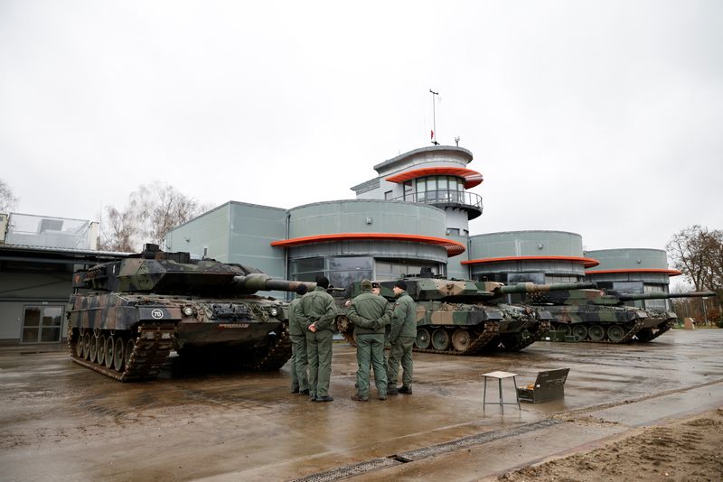 © Reuters. A Polish army instructor stands with Polish soldiers in front of a Leopard 2A5 in Swietoszow, Poland January 31, 2023. REUTERS/Kuba Stezycki