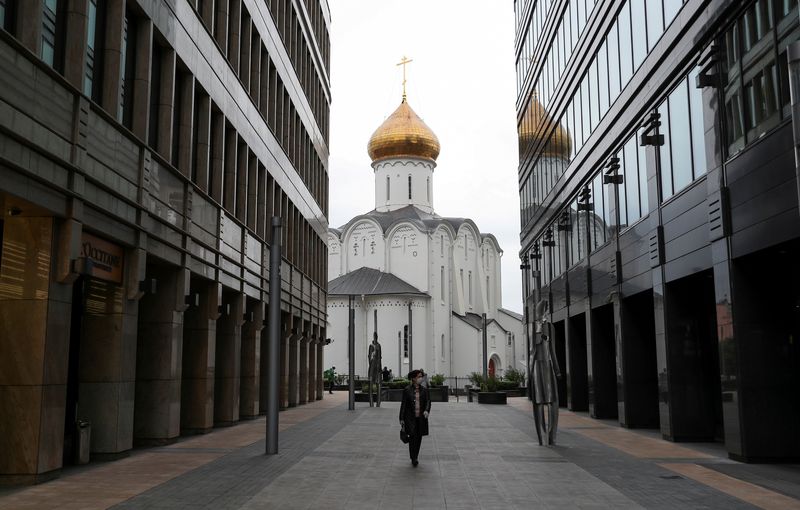 &copy; Reuters. FILE PHOTO: A woman wearing a protective face mask walks in a business district amid the outbreak of the coronavirus disease (COVID-19) in Moscow, Russia May 12, 2020. REUTERS/Evgenia Novozhenina/File Photo