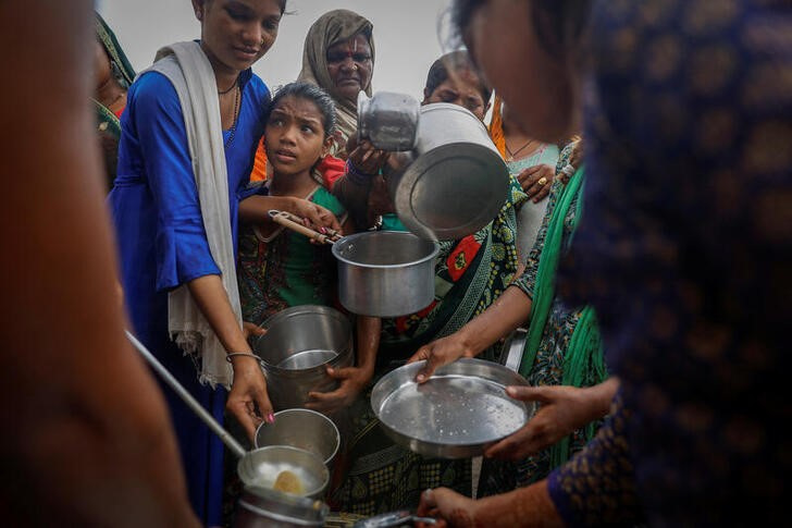&copy; Reuters. Foto ilustrativa del miércoles de un grupo de desplazados por la crecida de un río reciba comida en Nueva Delhi, India
 Jul 12, 2023. REUTERS/Adnan Abidi