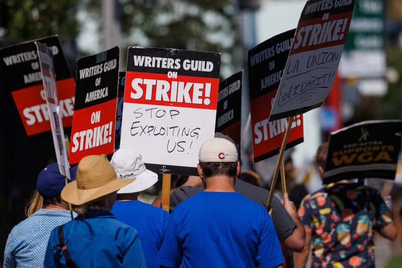 © Reuters. Striking Writers Guild of America (WGA) members walk the picket line in front of Netflix offices as SAG-AFTRA union announced it had agreed to a 'last-minute request' by the Alliance of Motion Picture and Television Producers for federal mediation, but it refused to again extend its existing labor contract past the 11:59 p.m. Wednesday negotiating deadline, in Los Angeles, California, U.S., July 12, 2023.   REUTERS/Mike Blake