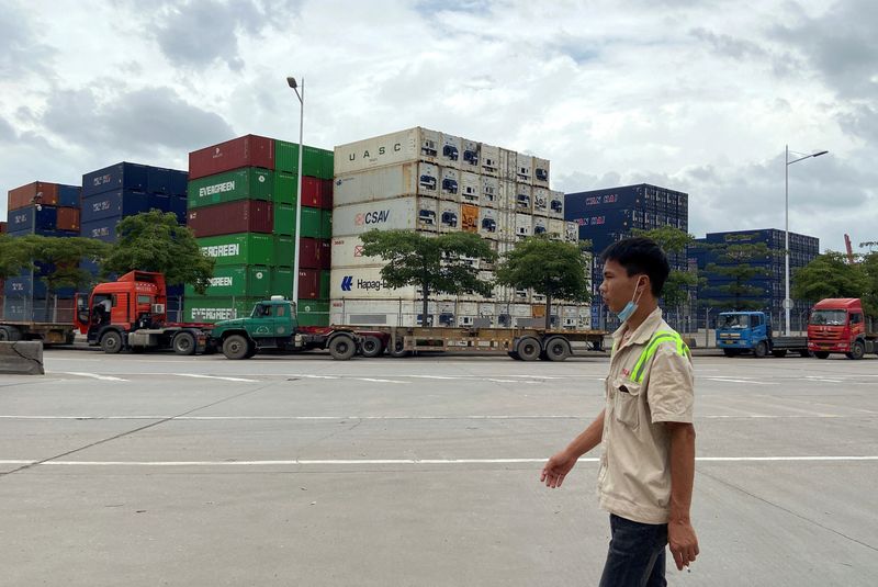 &copy; Reuters. FILE PHOTO: A man walks past containers at a port in Shenzhen, Guangdong province, China June 11, 2022.  REUTERS/David Kirton/File Photo