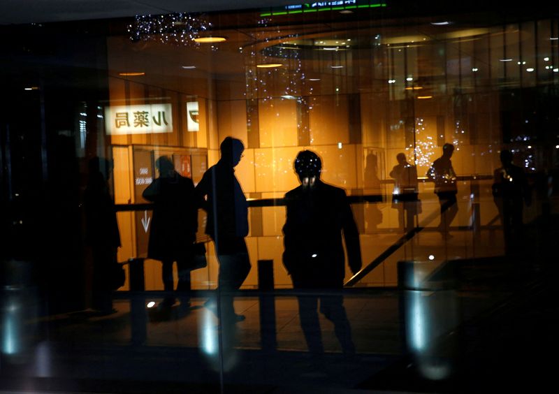 © Reuters. FILE PHOTO: Pedestrians are reflected on a window of a commercial building at closing hour at a financial district in Tokyo, Japan, November 22, 2017. REUTERS/Kim Kyung-Hoon/File Photo