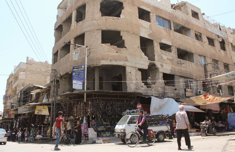 &copy; Reuters. أشخاص يسيرون أمام متاجر في دوما بسوريا يوم 19 يونيو تموز 2023. تصوير: فراس مقدسي - رويترز.