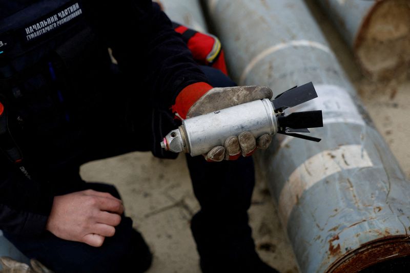 &copy; Reuters. FILE PHOTO: Ukrainian military serviceman Igor Ovcharruck holds a defused cluster bomb from an MSLR missile, among a display of pieces of rockets used by Russian army, that a Ukrainian munitions expert said did not explode on impact, in the region of Khar