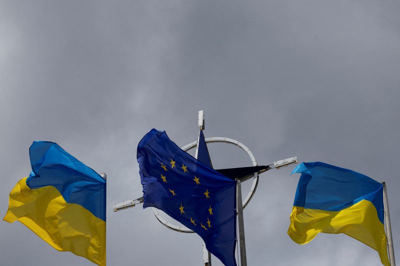 &copy; Reuters. Photo d'archives des drapeaux de l'Ukraine et de l'UE  qui se dressent devant l'emblème de l'Otan au centre de Kyiv. /Photo prise le 11 juillet 2023 à Kyiv, Ukraine/REUTERS/Valentyn Ogirenko