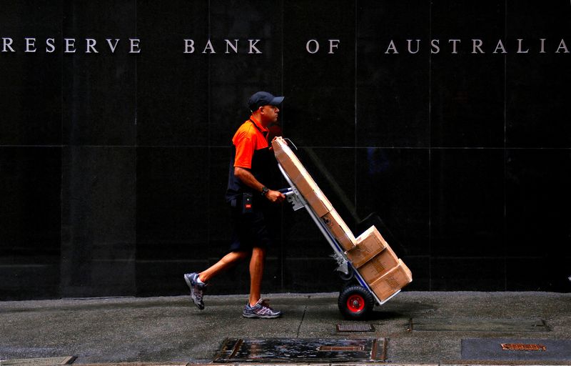 © Reuters. FILE PHOTO: A worker delivering parcels pushes a trolley past the Reserve Bank of Australia building in central Sydney, Australia, March 7, 2017.  REUTERS/David Gray/File Photo