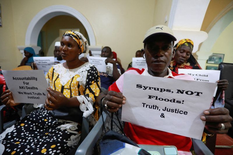&copy; Reuters. FILE PHOTO: Grieving parents hold up signs during a news conference, calling for justice for the deaths of children linked to contaminated cough syrups, in Serekunda, Gambia, November 4, 2022. In October 2022, the deaths of more than 70 Gambian children f