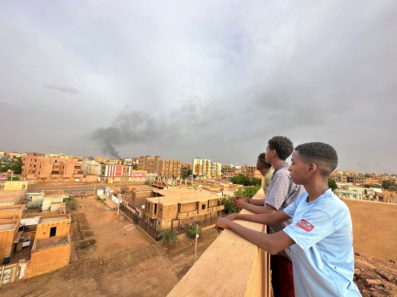 &copy; Reuters. Pessoas observam fumaça em Omdurman
 4/7/2023   REUTERS/Mostafa Saied