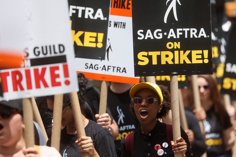 © Reuters. Striking Writers Guild of America (WGA) and Screen Actors Guild (SAG) members walk the picket line during their strike in New York City, U.S., July 14, 2023. REUTERS/Brendan Mcdermid