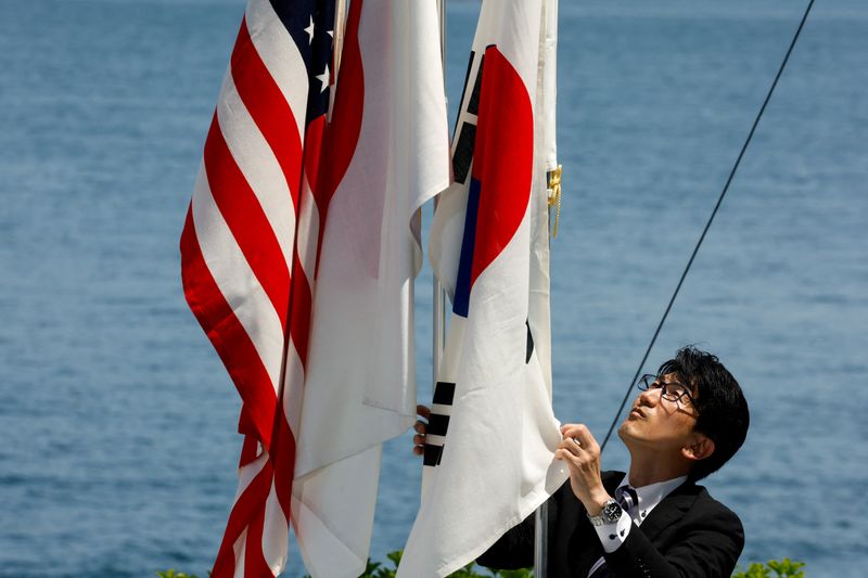 &copy; Reuters. 　韓国海軍は、北朝鮮による核・ミサイルの脅威に対抗するため、日米韓が７月１６日に日本海の公海上で合同ミサイル防衛訓練を実施したと発表した。写真は日米韓の国旗。広島で５月撮