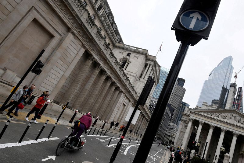 &copy; Reuters. FILE PHOTO: People cross a road in front of the Bank of England (BoE) building after the BoE became the first major world's central bank to raise rates since the coronavirus disease (COVID-19) pandemic, London, Britain, December 16, 2021. REUTERS/Toby Mel