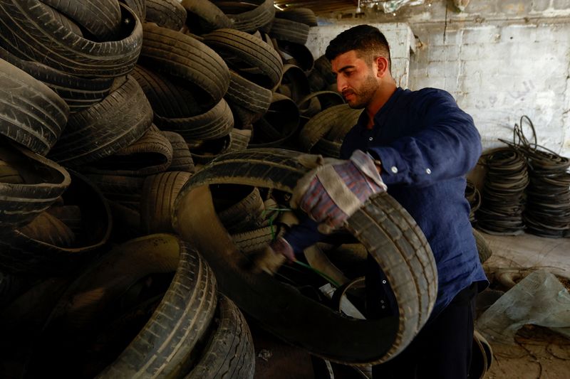 &copy; Reuters. الفلسطيني مدين حلس يعمل في ورشته لتحويل الإطارات المستعملة إلى مواد صديقة للبيئة يوم 11 يوليو تموز 2023. تصوير: إبراهيم ابو مصطفى - رويترز.