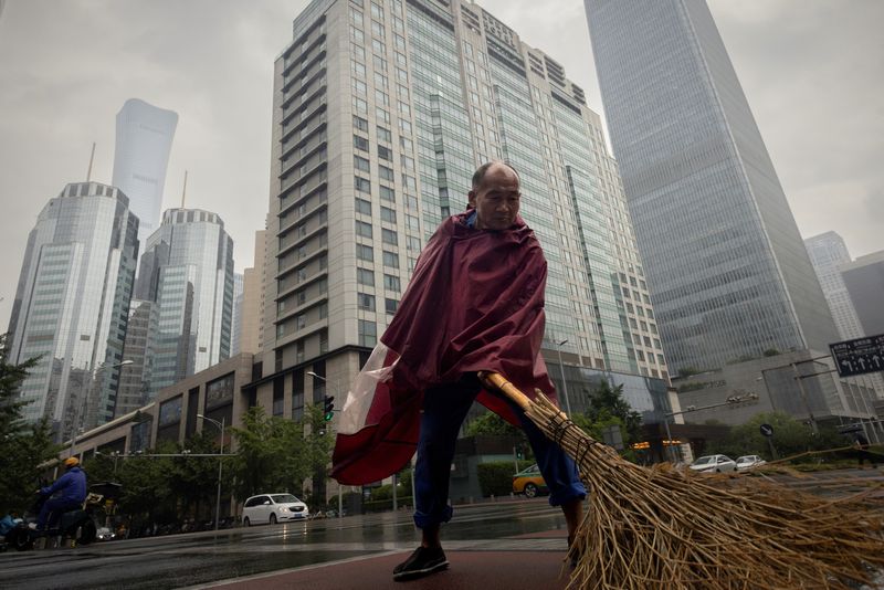 &copy; Reuters. FILE PHOTO: A worker sweeps a street in the Central Business District on a rainy day in Beijing, China, July 12, 2023. REUTERS/Thomas Peter